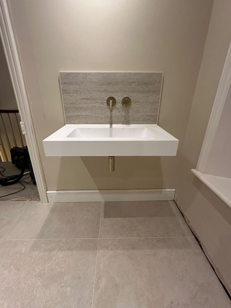 Wall-hung basin with wall-mounted brushed brass tap