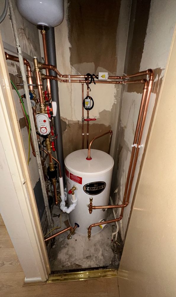 Hot water cylinder and copper pipework in a cupboard