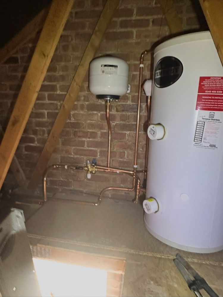 Hot water cylinder installed in a loft with an expansion vessel