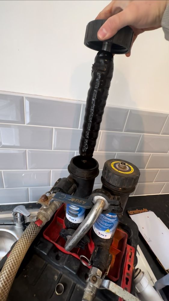 Magnetic filter rod coated in thick black sludge, pulled out during a power flush