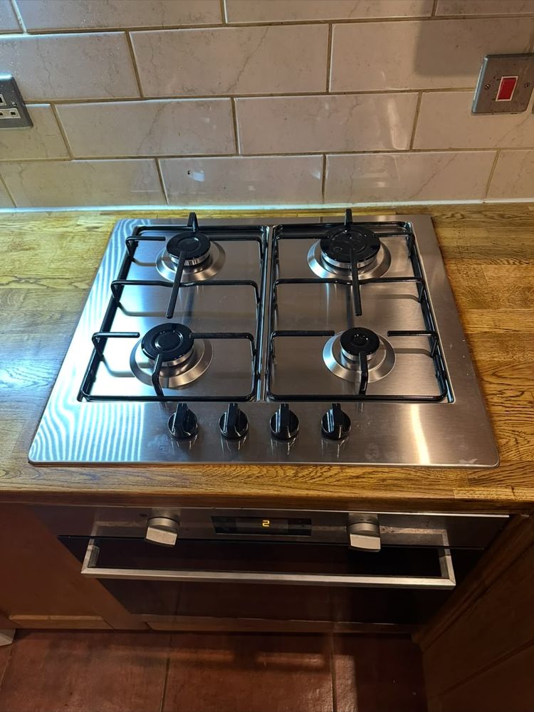 Four-burner stainless steel gas hob fitted into an oak worktop